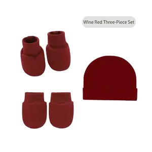 Three-piece infant set in wine red featuring cotton beanie, mittens and booties