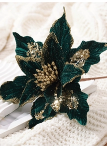 Détail d'une fleur de Noël en velours vert avec paillettes d'or sur tricot blanc