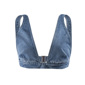 Dettaglio del top in denim blu con trama lavata e chiusura frontale con fibbia in metallo