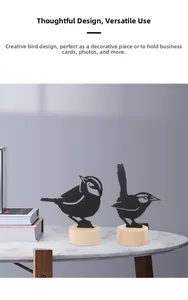 Close-up of black metal bird silhouette card holders on round wooden bases for desk decor