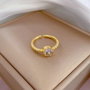 Macro view of gold open ring featuring a crown-set round zircon and bubble textured band