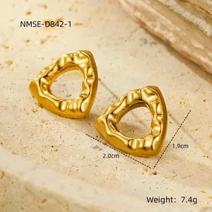 Detailed macro view of gold plated hollow triangle earrings with a textured hammer finish