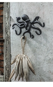 Detail eines Oktopus-Wandhakens aus Gusseisen mit rustikaler Textur an einer Wand