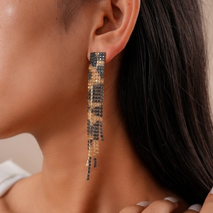 Elegant gold and black fringe drop earrings with rhinestones worn by a model