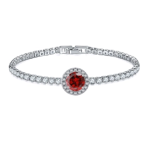 Macro shot of silver tennis bracelet with circular red gemstone and halo setting detail