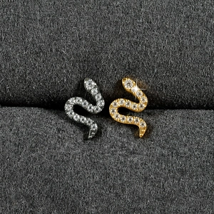Vue détaillée des piercings serpent en titane argent et or sertis de pierres en zircon