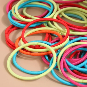 Primo piano di elastici per capelli colorati impilati in rosso, rosa e arancione