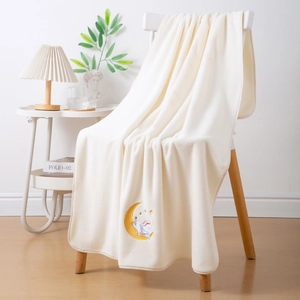 Detail showing moon rabbit embroidery on soft cream coral fleece thick bath towel