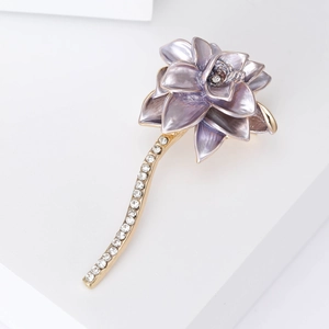 Macro detail of purple lotus brooch with golden stem and sparkling rhinestones