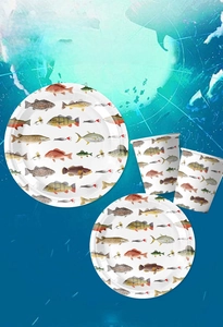 Macro shot of disposable paper plates and cups with realistic fish theme patterns