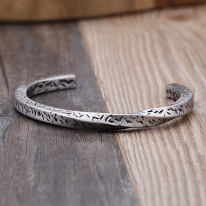 Close-up of vintage silver cuff bracelet with twisted texture and distressed engraving