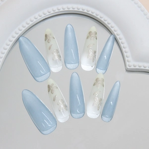 Blue cat eye press-on nails with white floral patterns in long almond shape