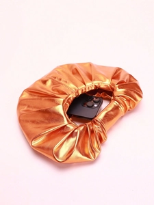 Metallic orange pleated cloud bag shown with smartphone inside to show capacity