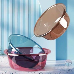 Detailed view of stackable thick transparent plastic washbasins in three modern colors