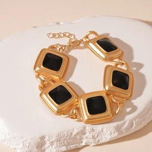 Detailed view of vintage gold bracelet with square black enamel links and lobster clasp