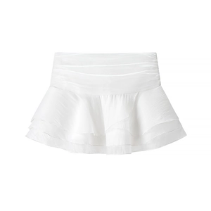 Detail of white tiered ruffle mini skirt featuring a smocked elastic waistband and flowy fabric