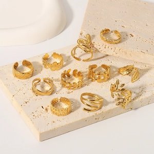 10-piece gold-plated stainless steel ring set featuring leaf and snake designs on travertine