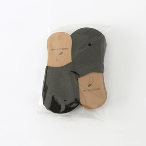 Detail view of double pair pack black invisible liner socks in transparent packaging