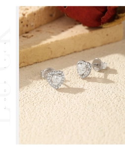 Detailed macro view of S925 sterling silver heart halo earrings on a stone texture