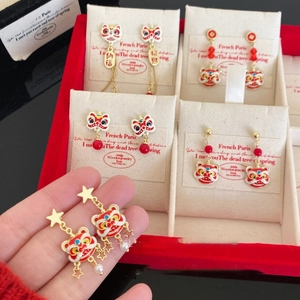 Close-up of red and gold lion dance earrings with Fu and Zhao Cai lucky charms