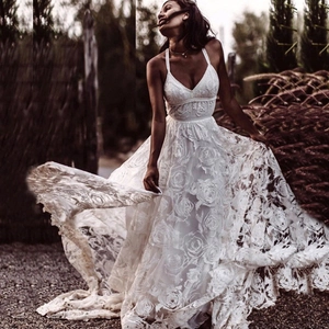 Dettaglio dell'abito da sposa in pizzo bianco con scollo a V e ricami floreali in rilievo