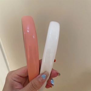 Close-up of pink and white vintage faux leather headbands with glossy finish