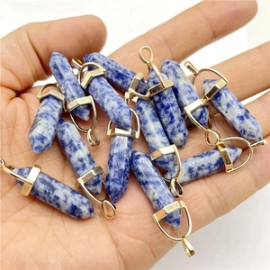 Natural sodalite hexagonal point pendants with gold plating held in hand