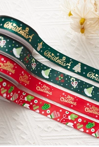 Close-up of red and green Merry Christmas ribbons with gold foil patterns for gift wrapping