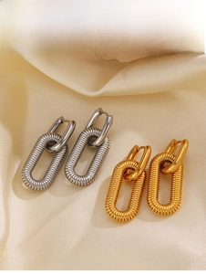 Detail of gold and silver oval link earrings with textured finish on silk background
