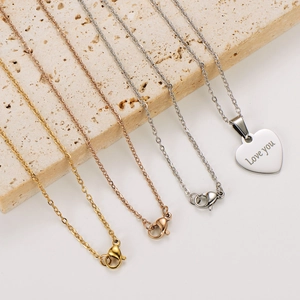 Close-up of gold, rose gold and silver heart necklaces with Love You engraving