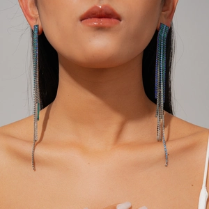 Close-up of long blue-green gradient tassel earrings with rhinestones on model