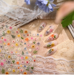 Macro detail of Monet-style floral nail stickers applied on soft pink manicure