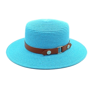 Detailed close-up of blue straw sun hat featuring brown faux leather belt and metal buckle