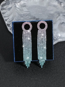 Close-up of pink and blue gradient rhinestone fringe earrings in a velvet gift box