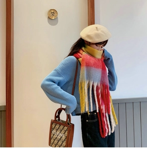Detail of colorful plaid scarf featuring long tassels and soft knitted texture for winter
