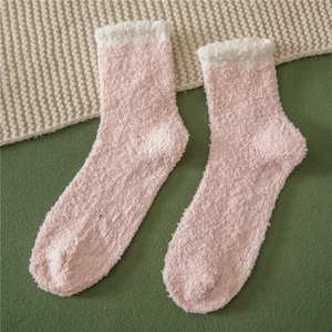 Detail of coral fleece slipper socks featuring non-slip grippers and soft white trim