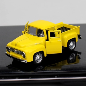Macro shot of yellow vintage pickup truck model with open doors on reflective surface