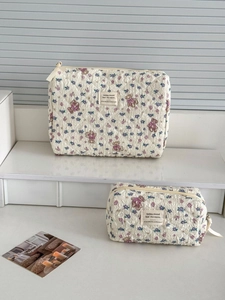 Macro detail of quilted fabric texture and purple floral bear patterns on cosmetic bag set