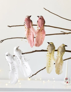 Detail of colorful feathered birds with glitter accents on branches for Christmas decor