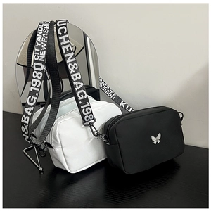 Detail of white and black nylon crossbody bags with silver butterfly and letter straps
