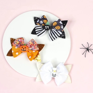 Three Halloween bow hair clips with pumpkin spider and ghost icons on pink background