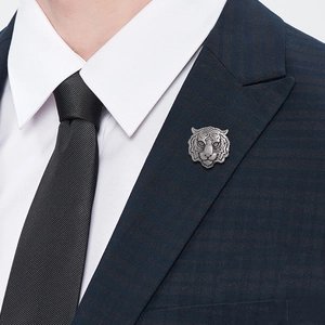 Men's silver tiger head brooch on a navy checkered blazer with detailed metal relief
