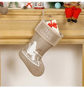 Close-up of linen Christmas stocking with Santa sleigh silhouette on fireplace