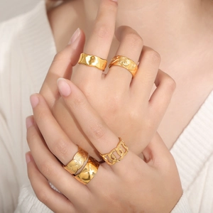 Set of five gold plated titanium steel rings with diverse geometric textures and hammered patterns