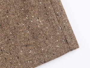 Gros plan du tissu en tweed marron avec motif à chevrons et texture vintage