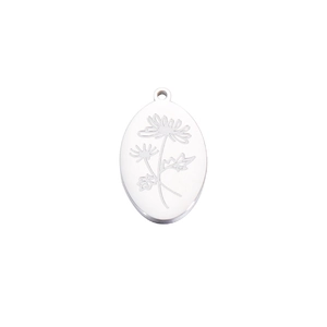 Macro shot of oval stainless steel necklace pendant with engraved floral birth month pattern