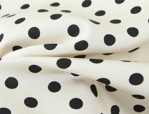 Macro shot of French vintage polka dot dress fabric showing smooth cream satin texture