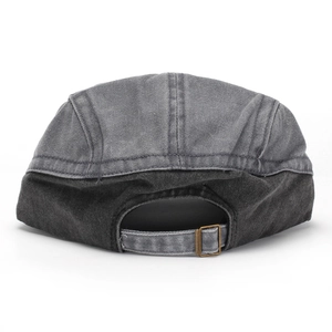 Close-up of washed cotton flat cap with adjustable metal buckle and contrast stitching