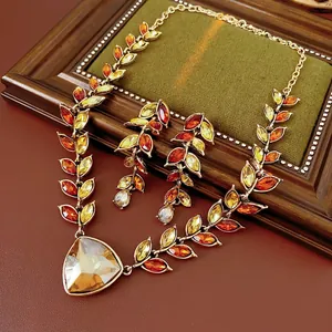 Parure vintage en or avec pompon de blé et pierres ambrées sur un fond en cuir rétro