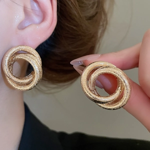 Close-up of golden interlocking triple rings with fine frosted metallic texture